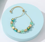 Friendship bracelet with gold chain and aqua blue, gold and light green natural stone stations