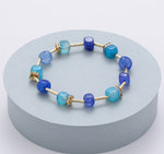 Elasticated bracelet with aqua blue, true navy and sea blue polished-glass beads