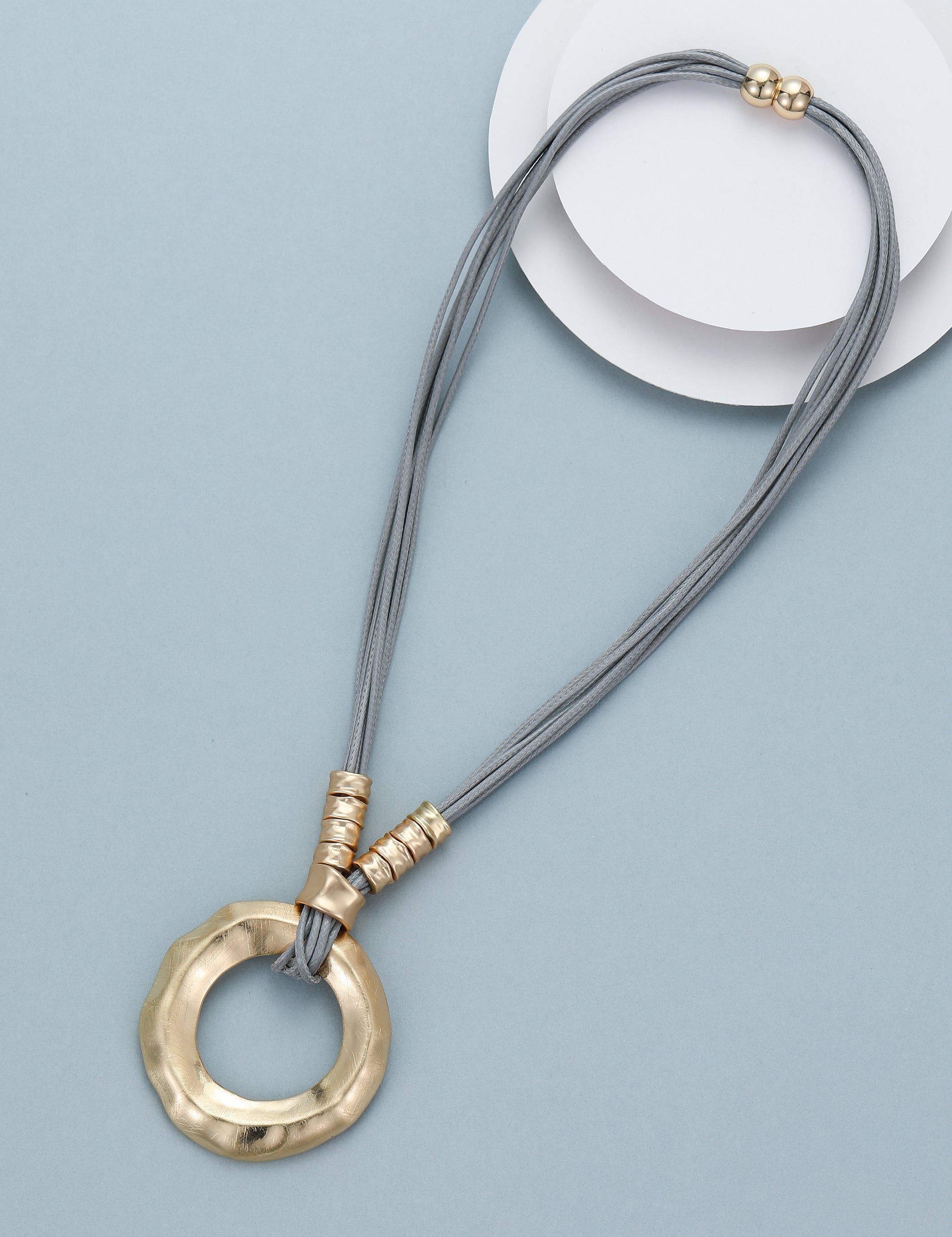 Short necklace, with gold-toned open circular pendant and magnetic opening/closure  - on leather strands