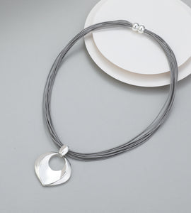 Short necklace, with open shiny silver circular pendant drop and magnetic opening/closure  - on leather strands