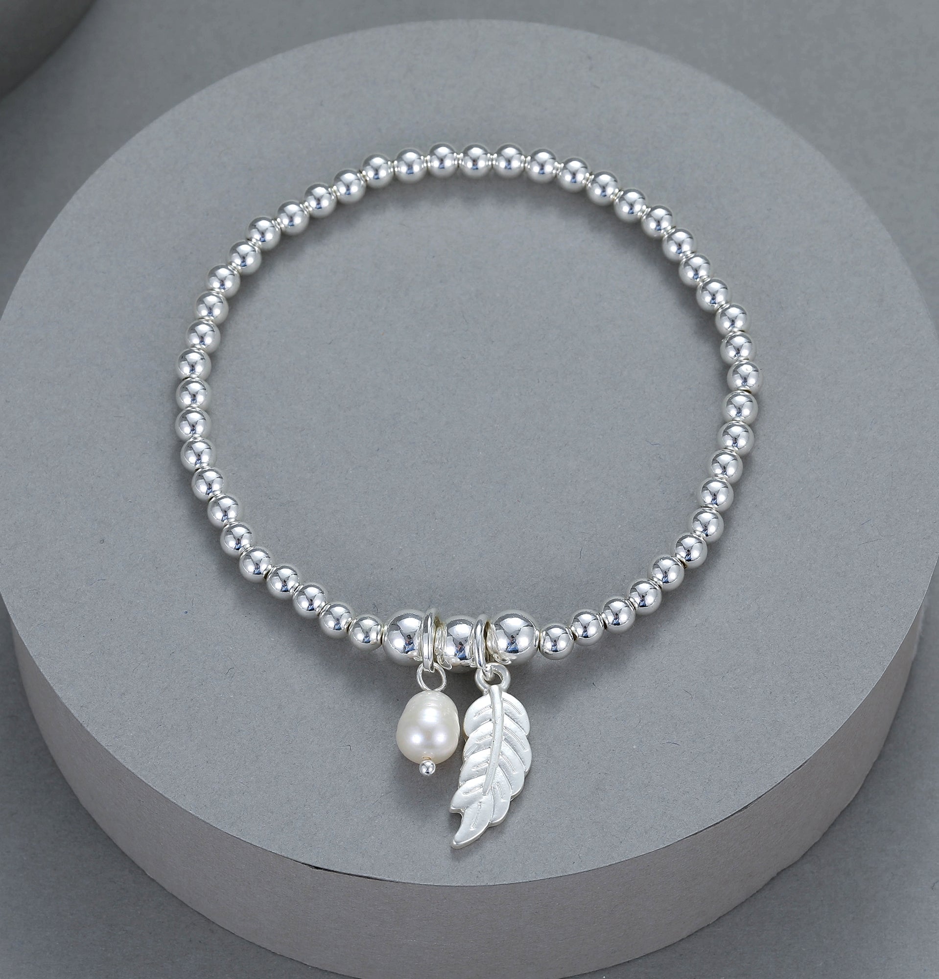 Elastic bracelet with feather and pearl pendant drop in silver