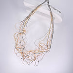 Short necklace, with ‘spaghetti’ type twists in rose gold, gold and silver, with extension chain